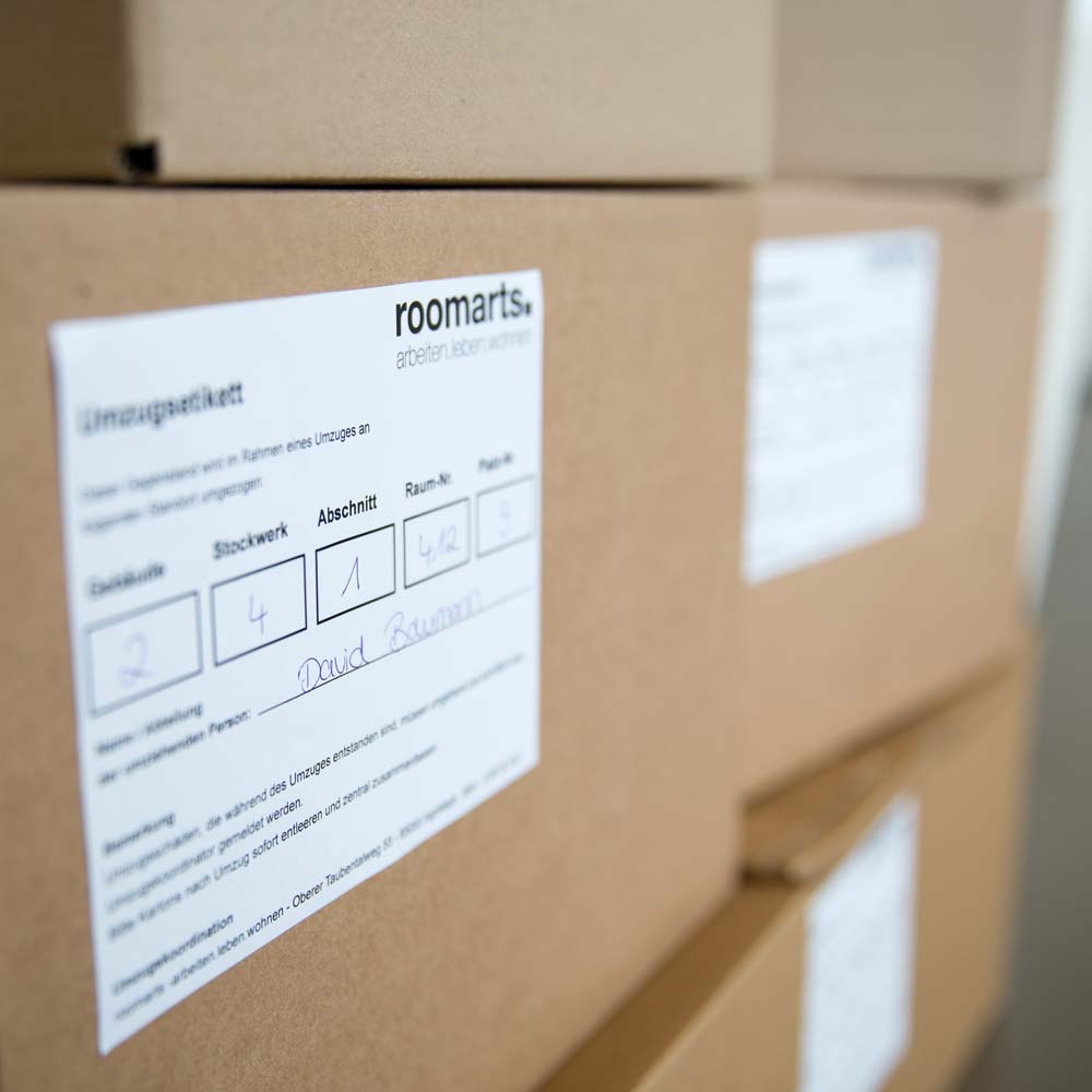 Gestapelte versandfertige Pakete mit Umzugsetiketten.