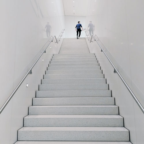 Ein Mann läuft eine lange weiße Treppe hinauf.